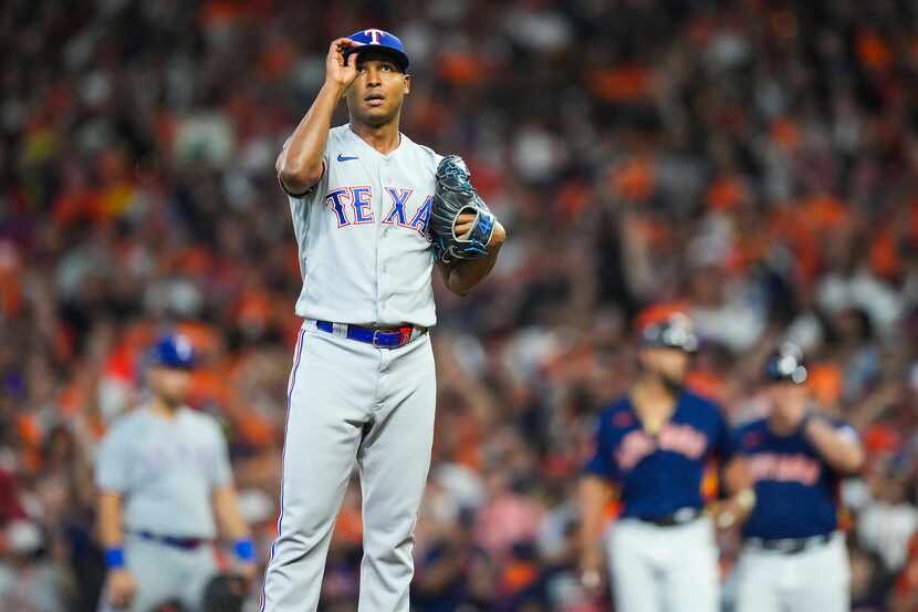 Texas Rangers relief pitcher Jose Leclerc adjusts his cap between pitches during the eighth...