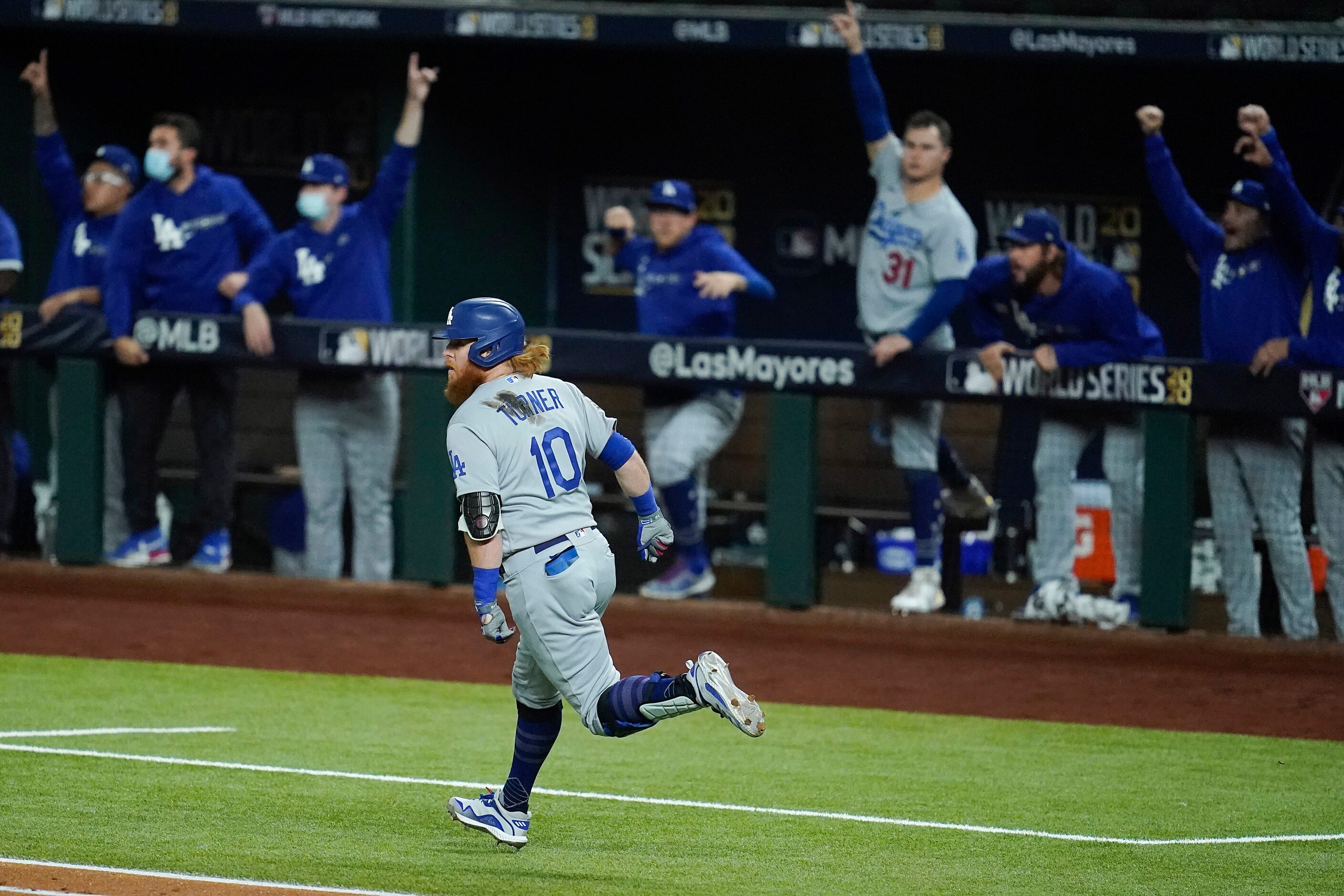 Los Angeles Dodgers third baseman Justin Turner watches as his solo home run clears the...