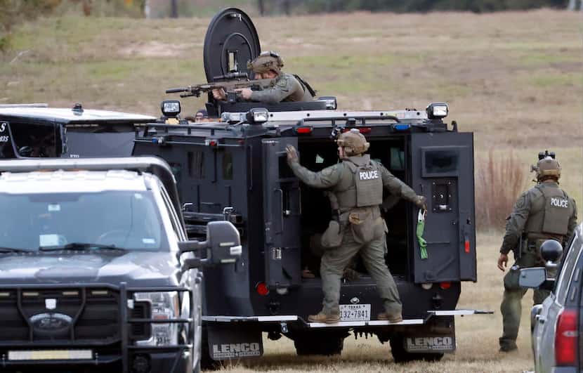 Fort Worth police SWAT officers take up a position on the backside of Lynnwood Hills Drive,...