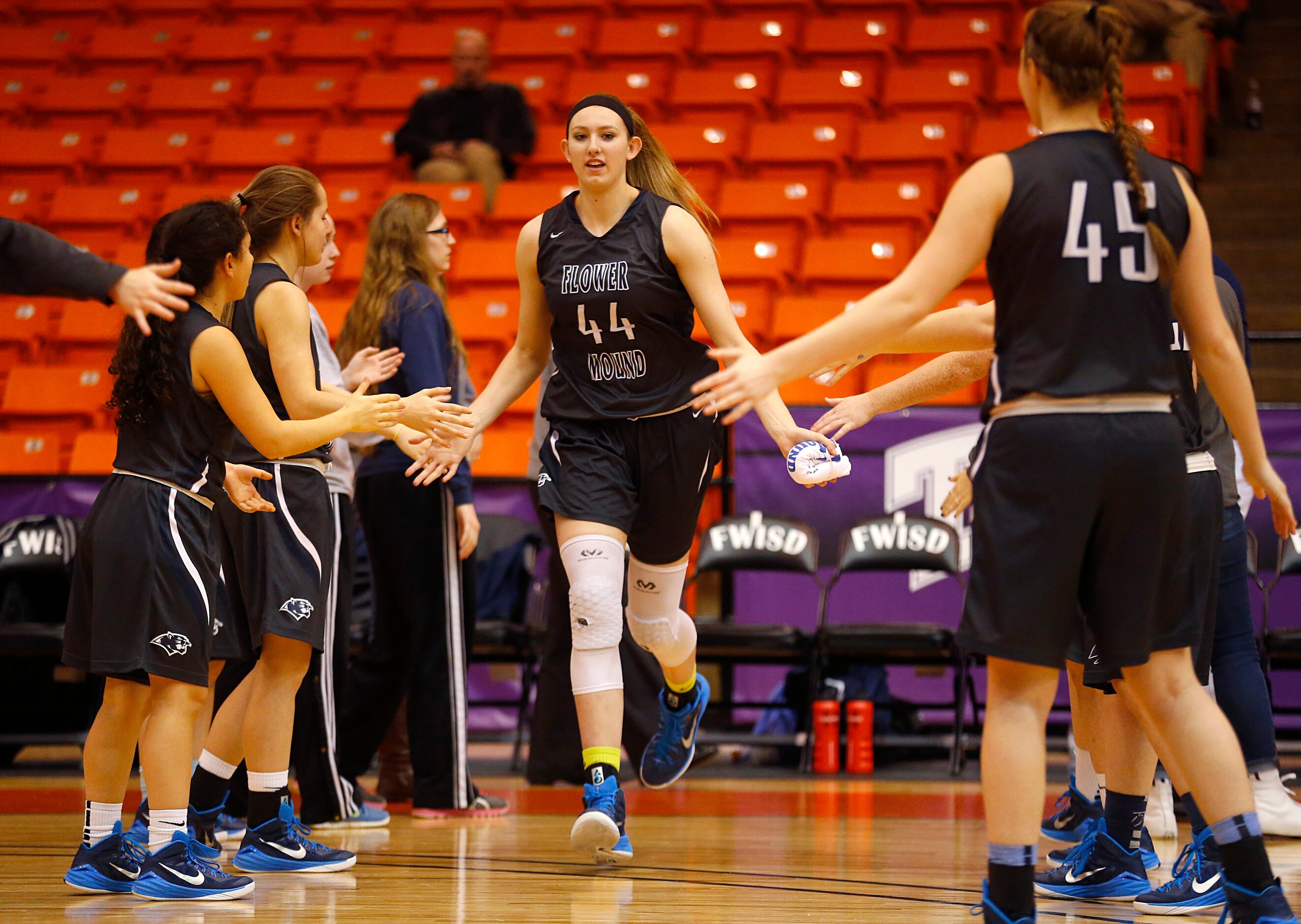 Flower Mound center Lauren Cox (44) slaps hands with teammates as she is introduced before...