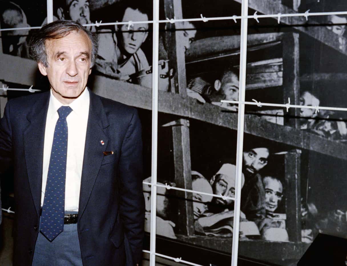 Nobel Peace prize winner and writer Elie Wiesel stands in front of a photo of himself...