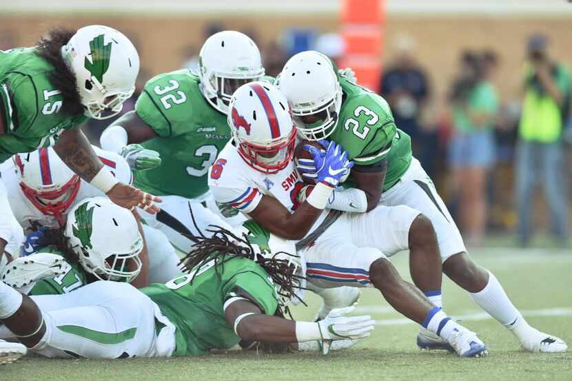 North Texas junior defensive end Joshua Wheeler (18) and junior defensive back Kishawn...