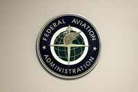 FILE - A Federal Aviation Administration sign hangs in the tower at John F. Kennedy...