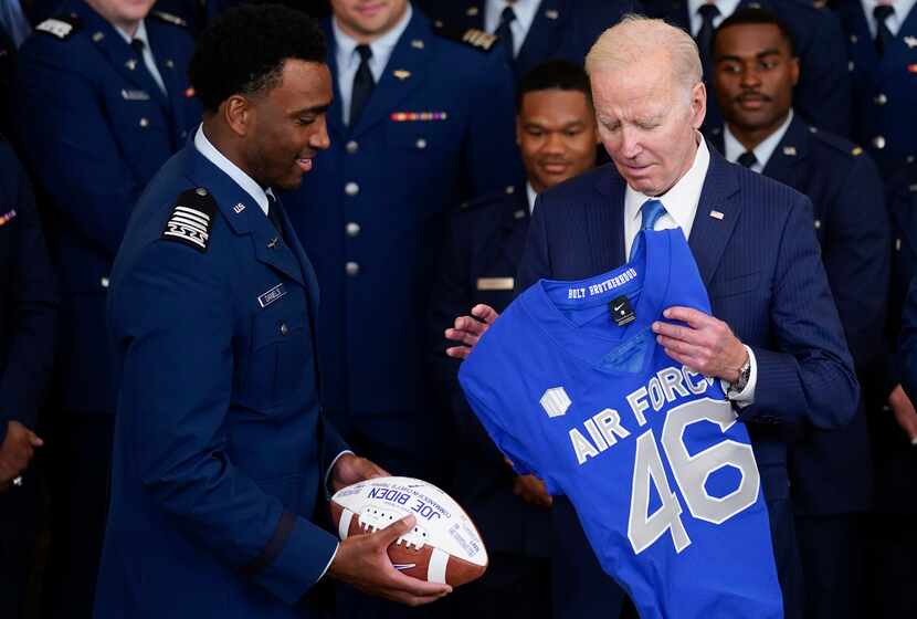 Air Force quarterback Haaziq Daniels (left) presented President Joe Biden with a jersey...