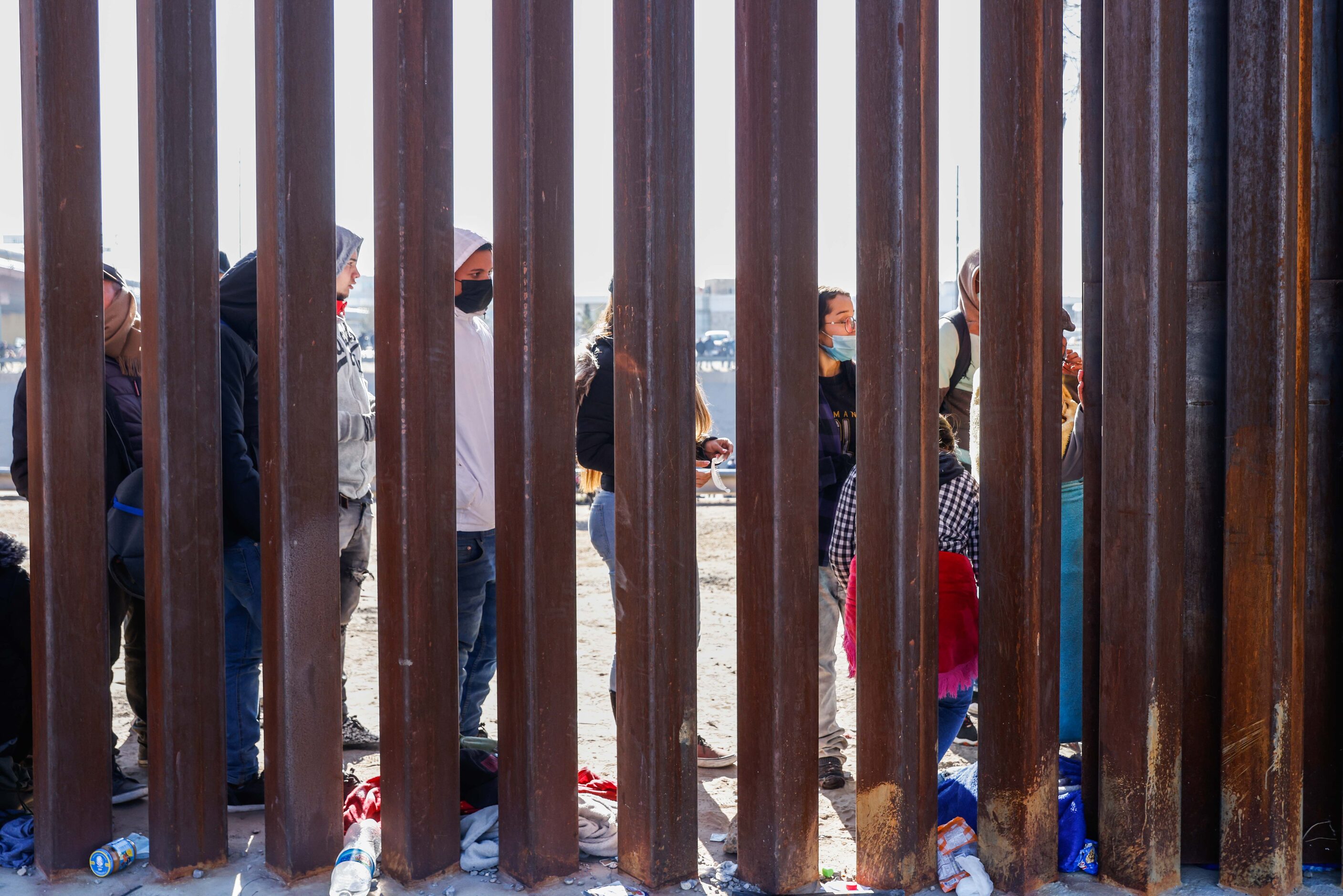 Migrants stand in line at a US-Mexico border gate from the banks of the Rio Grande River in...