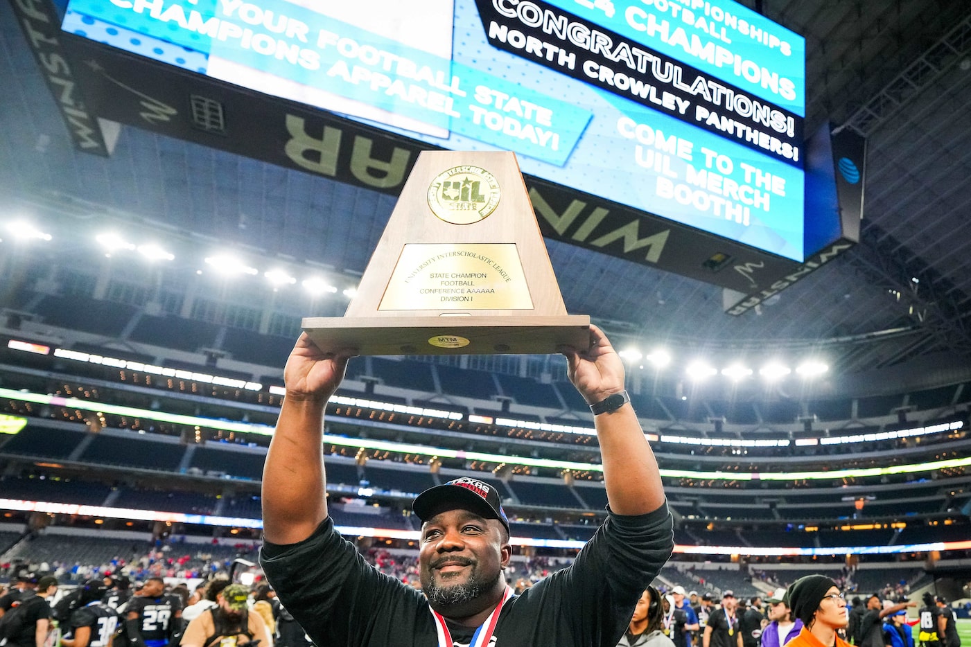 North Crowley head coach Ray Gates lifts the championship trophy toward the crowd after a...