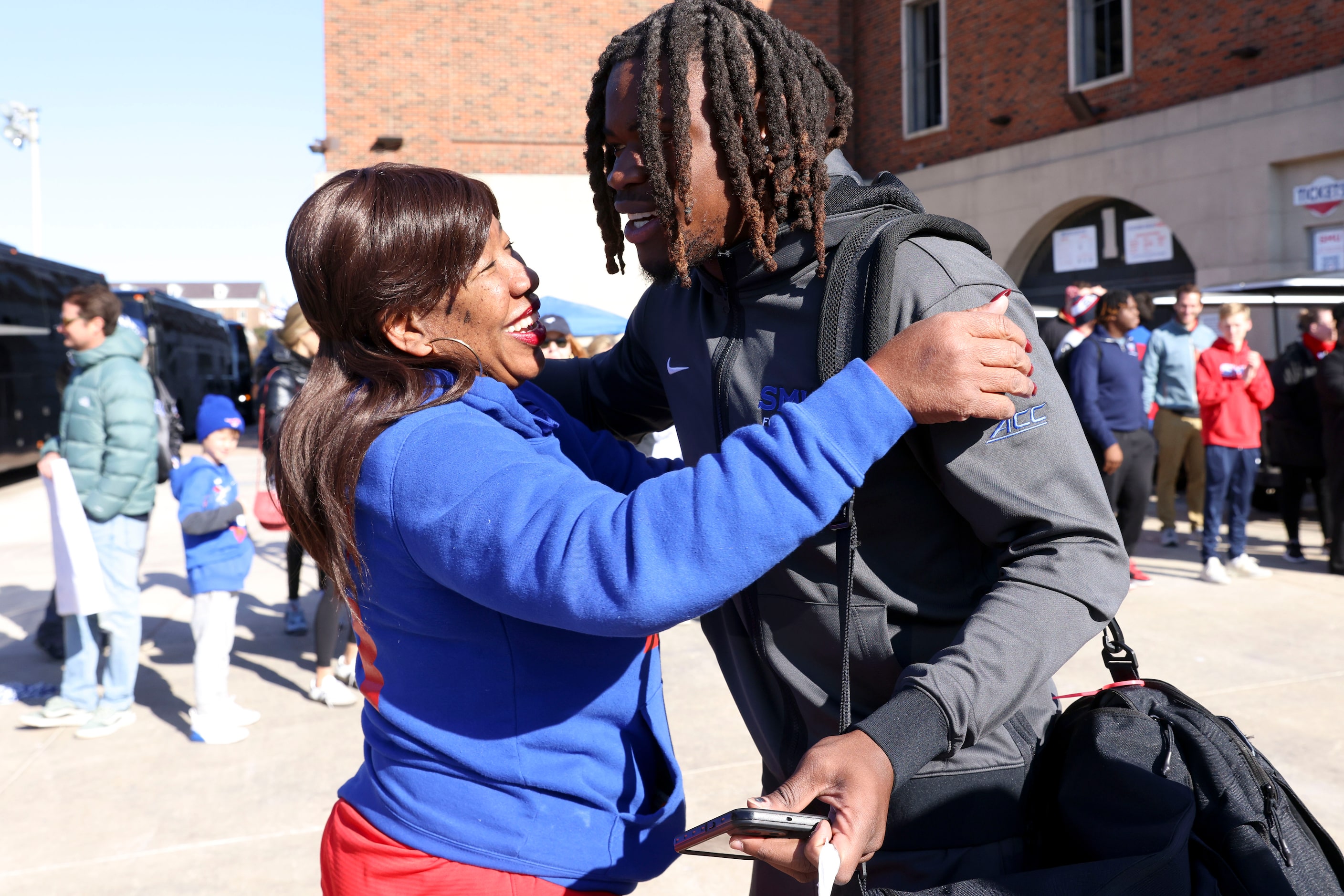 Linda Leach, greets her son Isaiah Nwokobia as he makes his way out towards the team bus...