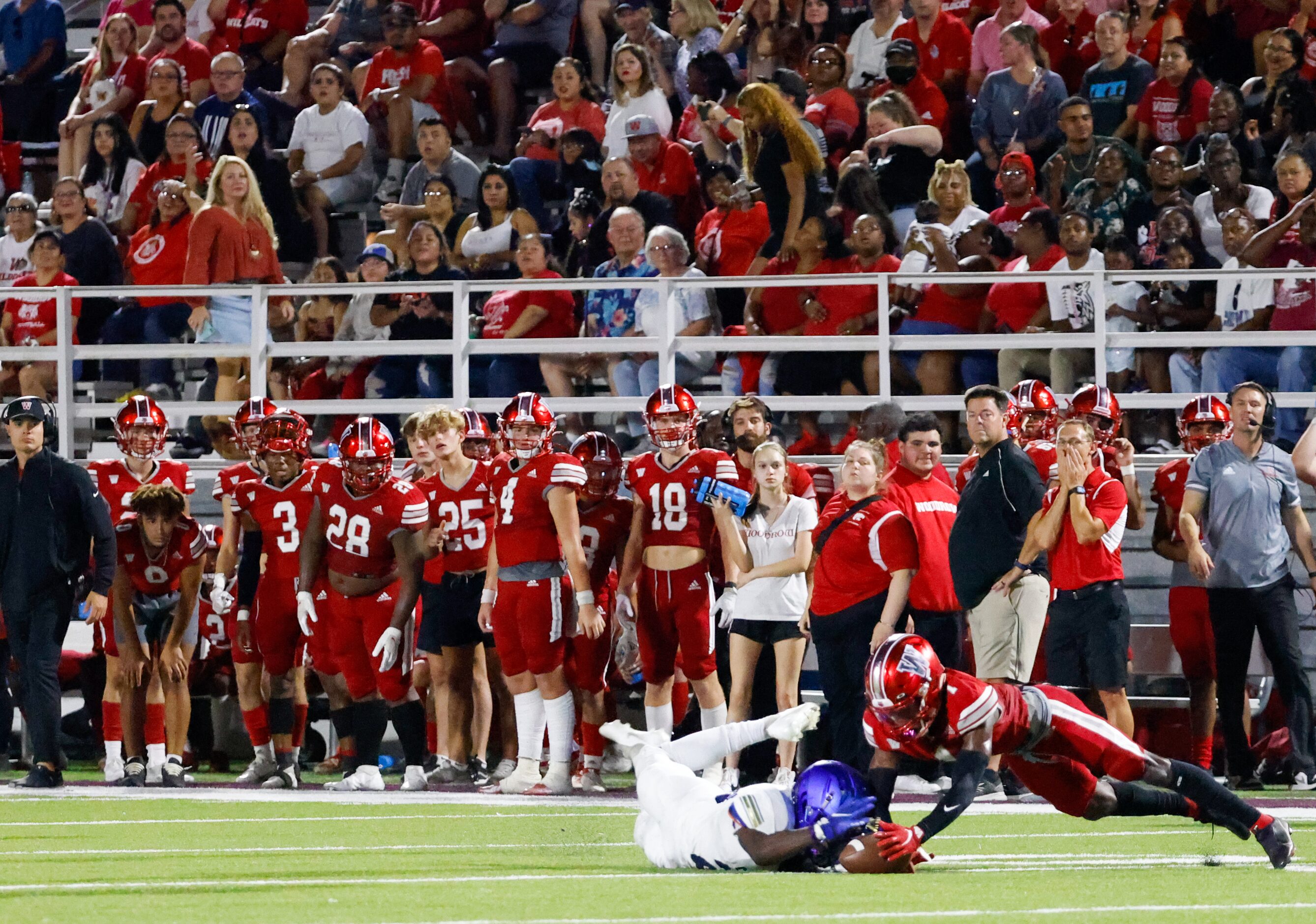 Woodrow Wilson players, fans and staff watch as wide receiver Cyris Taylor (1) and Conrad...