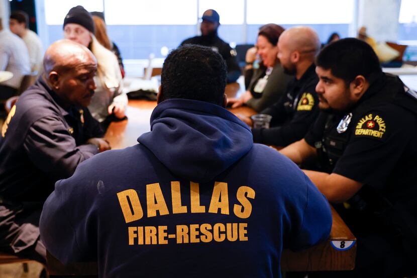 People, including the first responders, engage during the fifth annual Thanksgiving dinner...