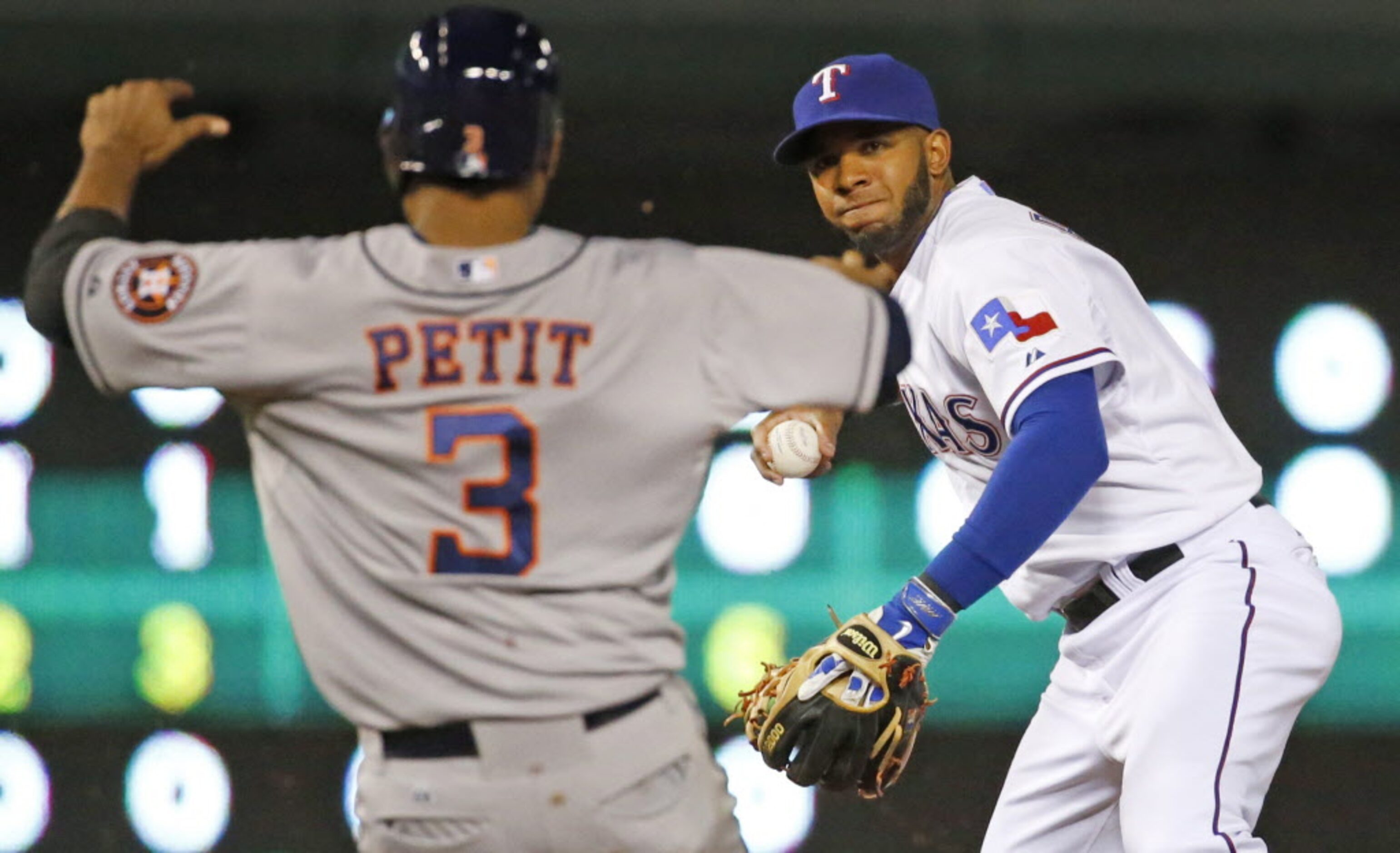 Texas shortstop Elvis Andrus turns the pivot at second base on a double play in the fifth...