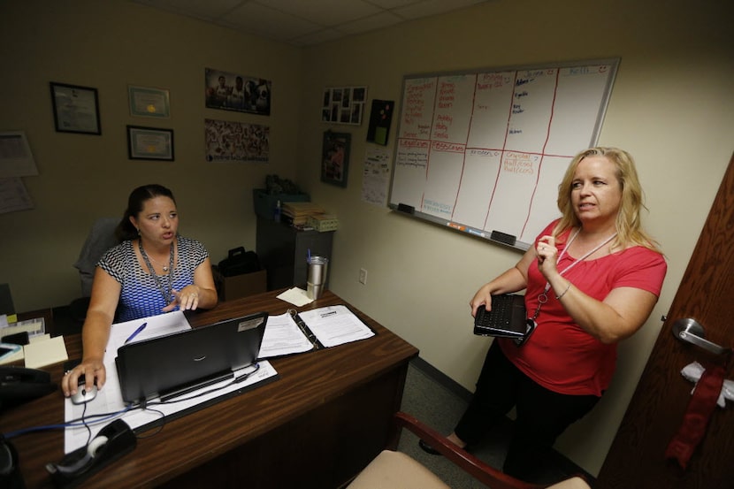 Tarrant County CPS child-abuse investigator Kelli Bailey (right) talks to her supervisor,...