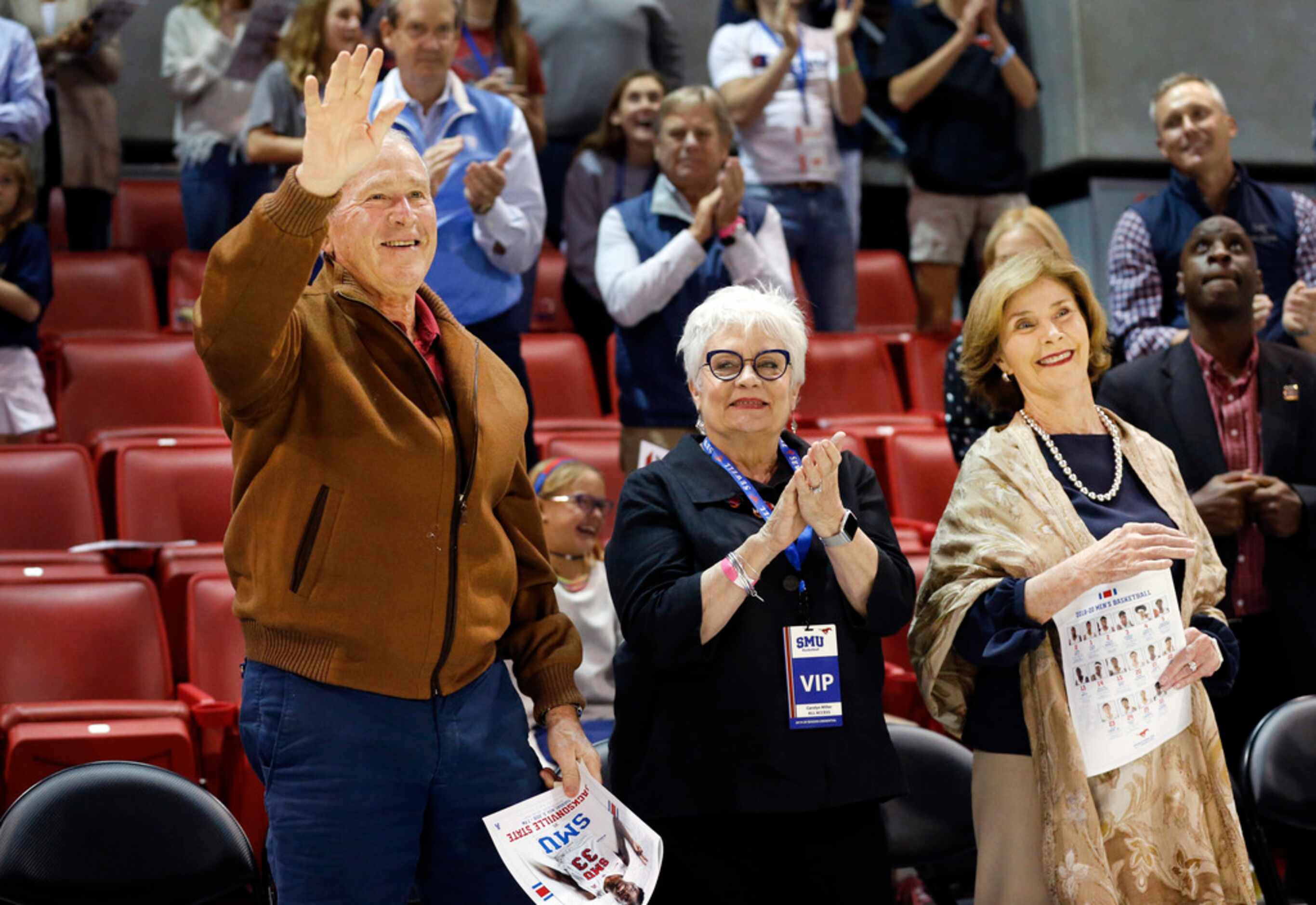 Fans applaud former President George W. Bush (left) and First Lady Laura Bush's (right) 42nd...