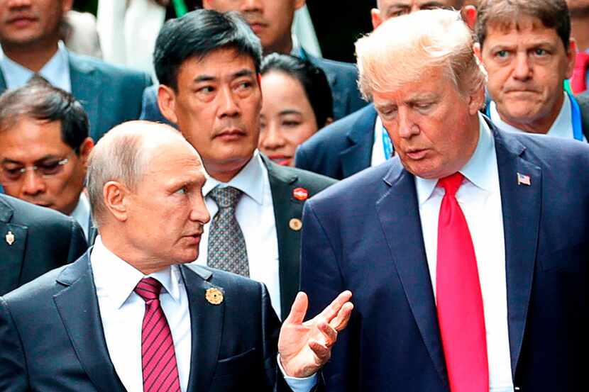 President Donald Trump (right) and Russian President Vladimir Putin talk during a photo...