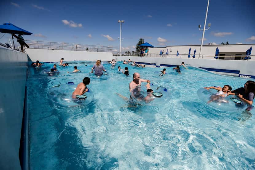 Swimmers ride the waves of Epic Waves, a 10,000 square-foot, 300,000 gallon wave pool, at...