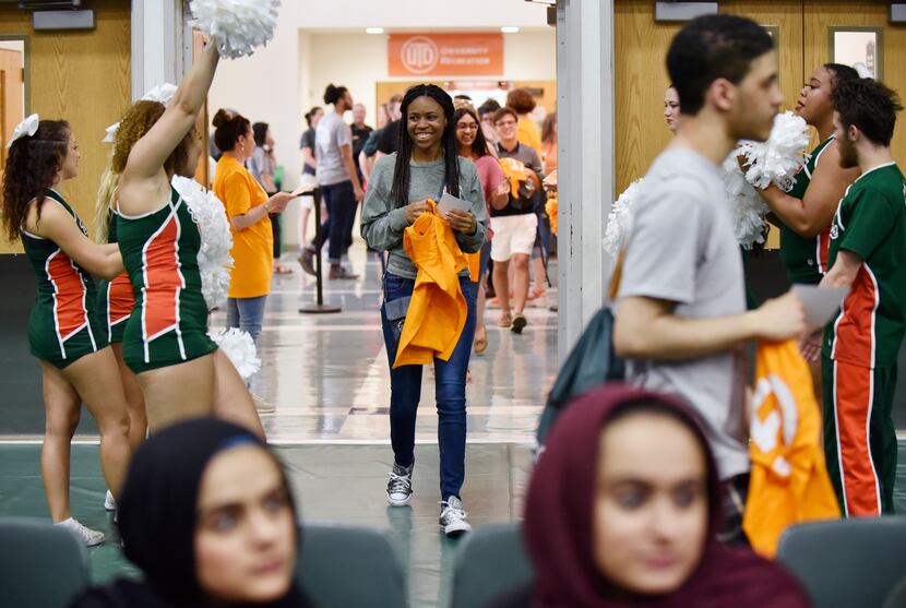 A new student smiles as she's greeted by the UTD cheerleaders before the start of a new...