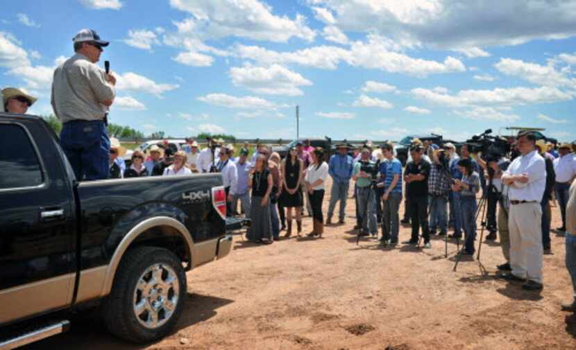  Clay County land owner Tommy Henderson, standing in pickup, addresses a group during a news...