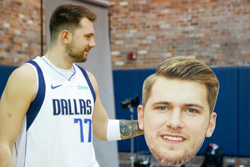 Dallas Mavericks guard Luka Doncic (77) looks at a cutout of his own face during media day...