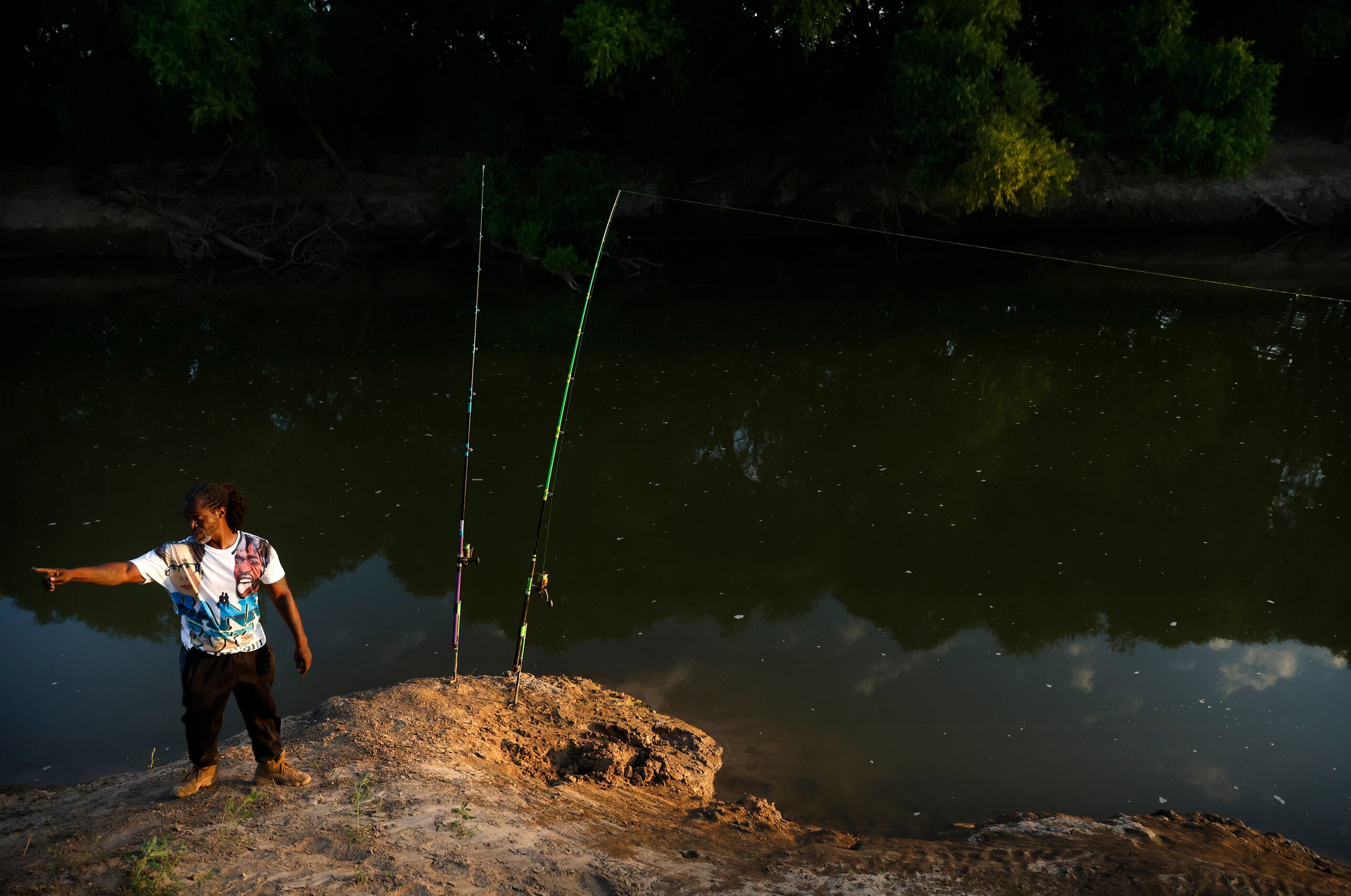 Odell Allen sets his 12 ft rods on the banks of the Trinity River hoping to catch an...