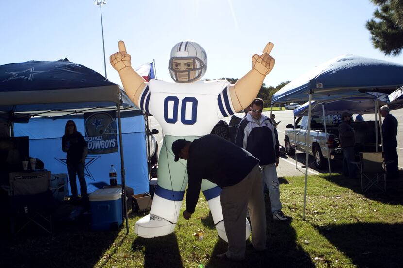 Jason Smith of McKinney stakes a big Dallas Cowboys air mascot before a game between the...