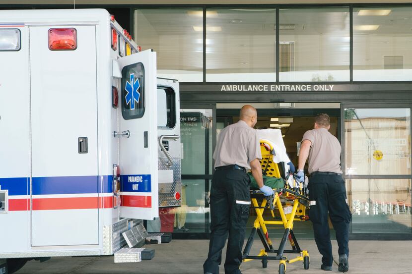 Paramedics take a gurney into a hospital