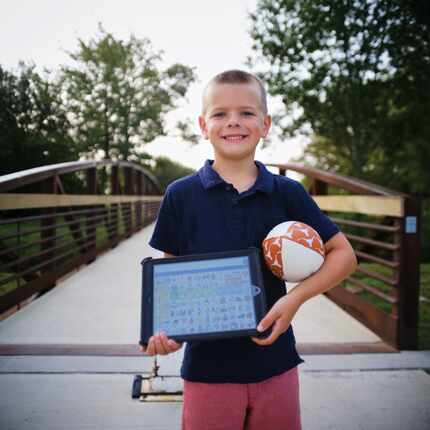 A young boy shows off a learning tool provided by the Callier Center for Communication...