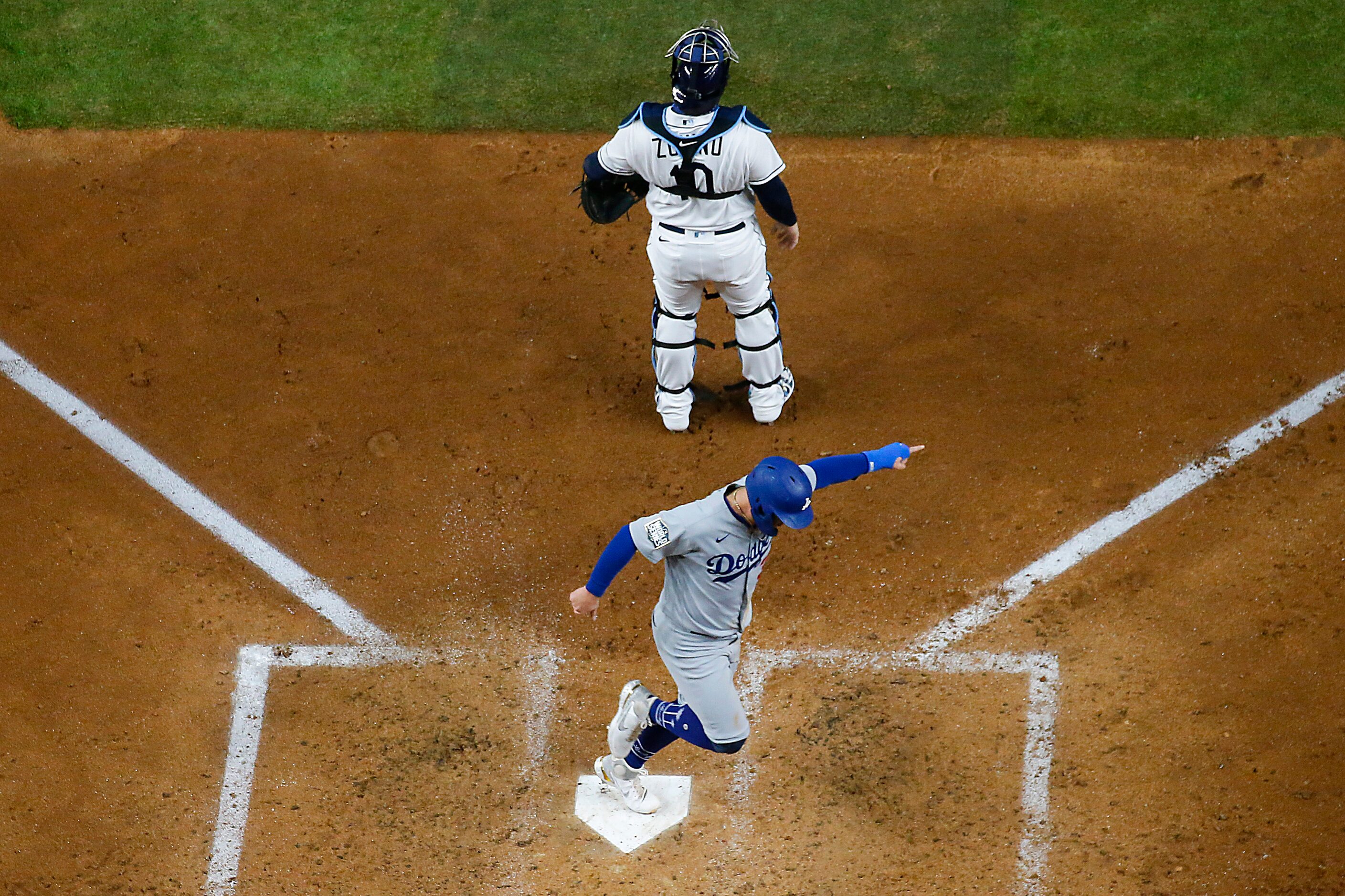 Los Angeles Dodgers left fielder Joc Pederson celebrates as he scores past Tampa Bay Rays...