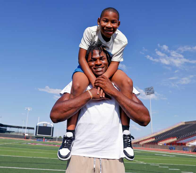 Duncanville defensive lineman Colin Simmons carries his brother Clayton Roberts, 8, at...