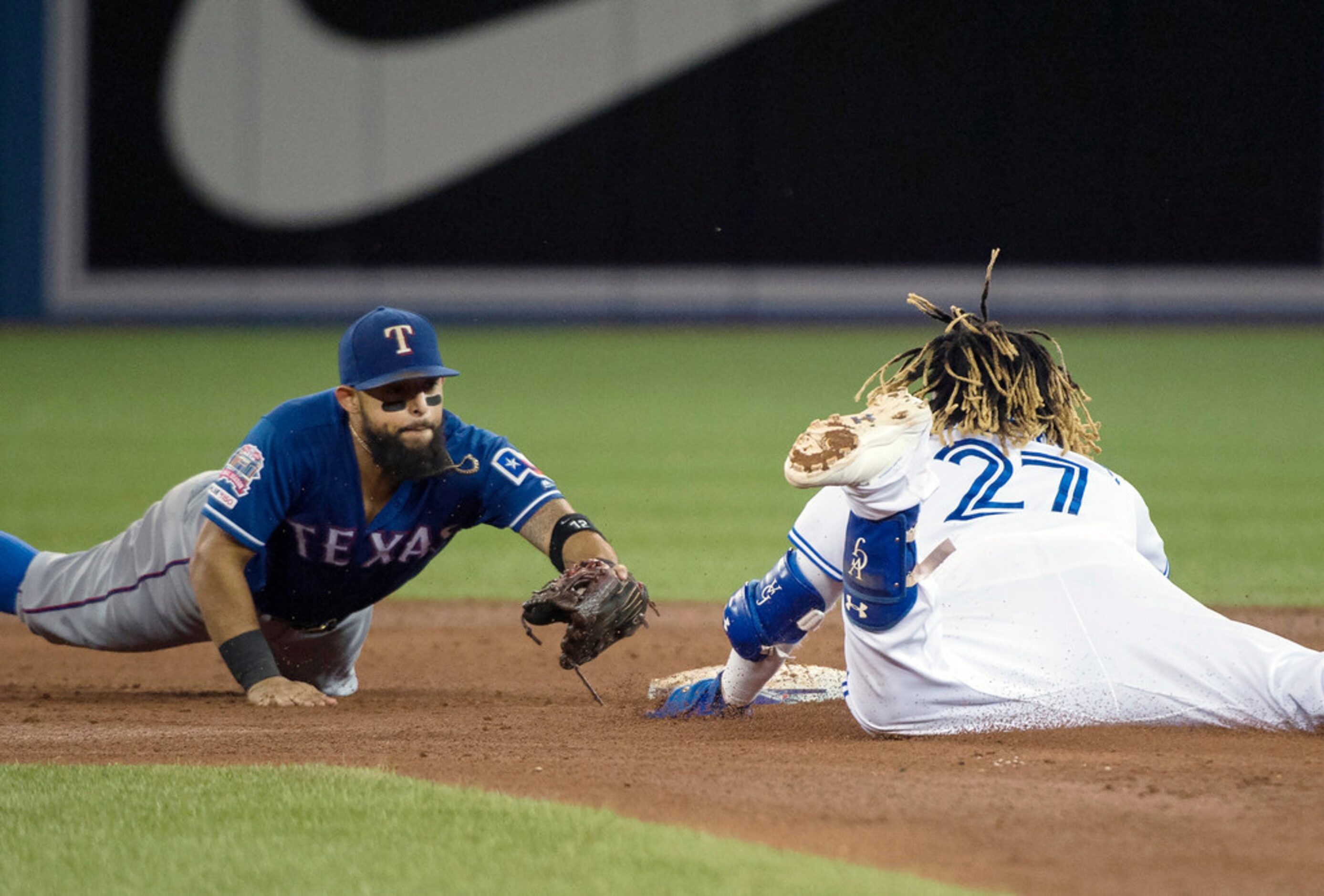 Toronto Blue Jays third baseman Vladimir Guerrero Jr. (27) slides safe past Texas Rangers...