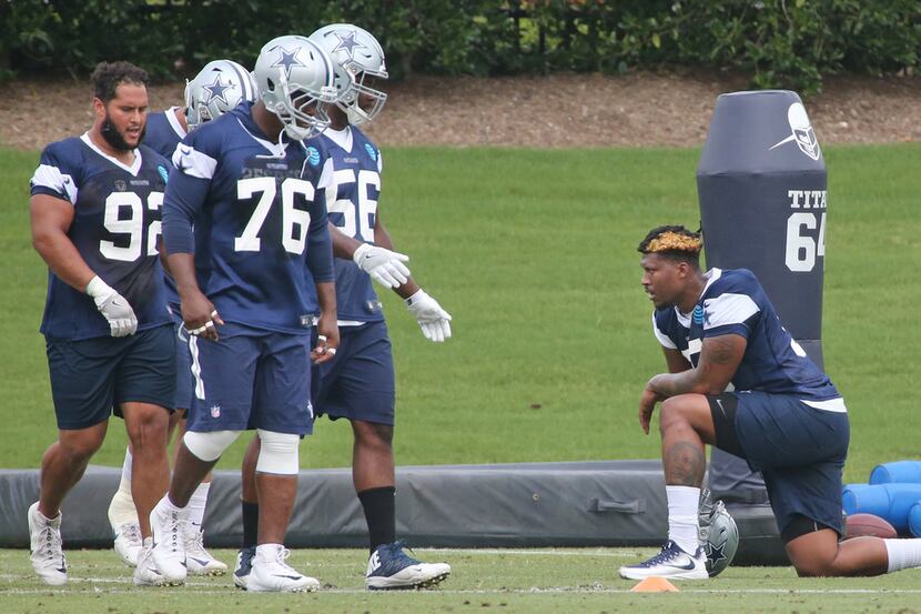 Dallas Cowboys defensive tackle David Irving (95), right, takes a knee as he watches his...