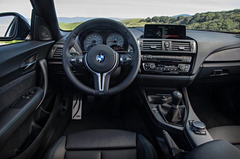 
The interior is standard-issue black with a shallow plastic dash that wraps around a...