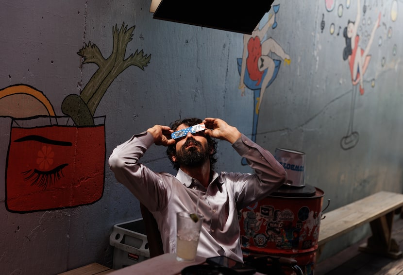 Jonathan Dengle watches the total eclipse at The Goat in Dallas on Monday, on April 8, 2024