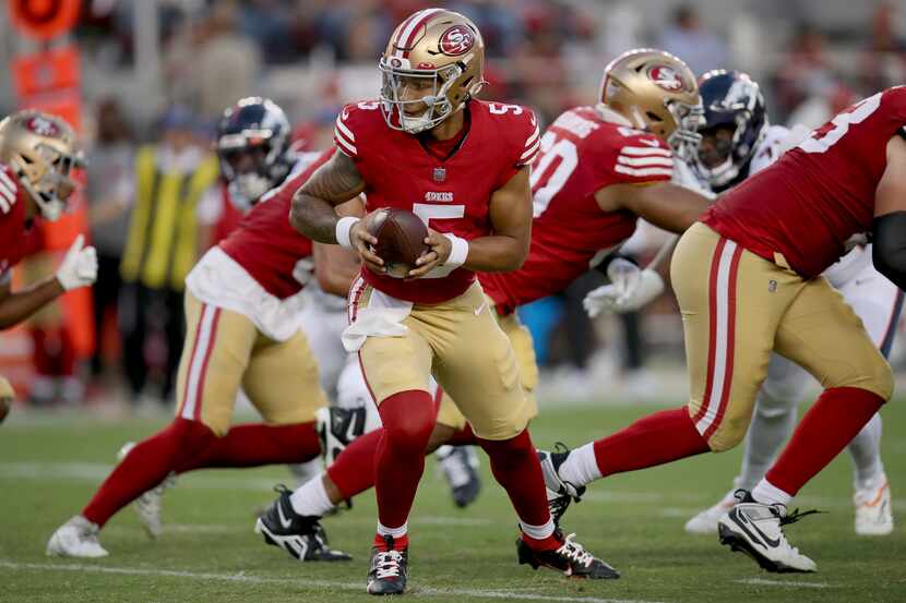 San Francisco 49ers quarterback Trey Lance (5) hands off the ball during an NFL football...