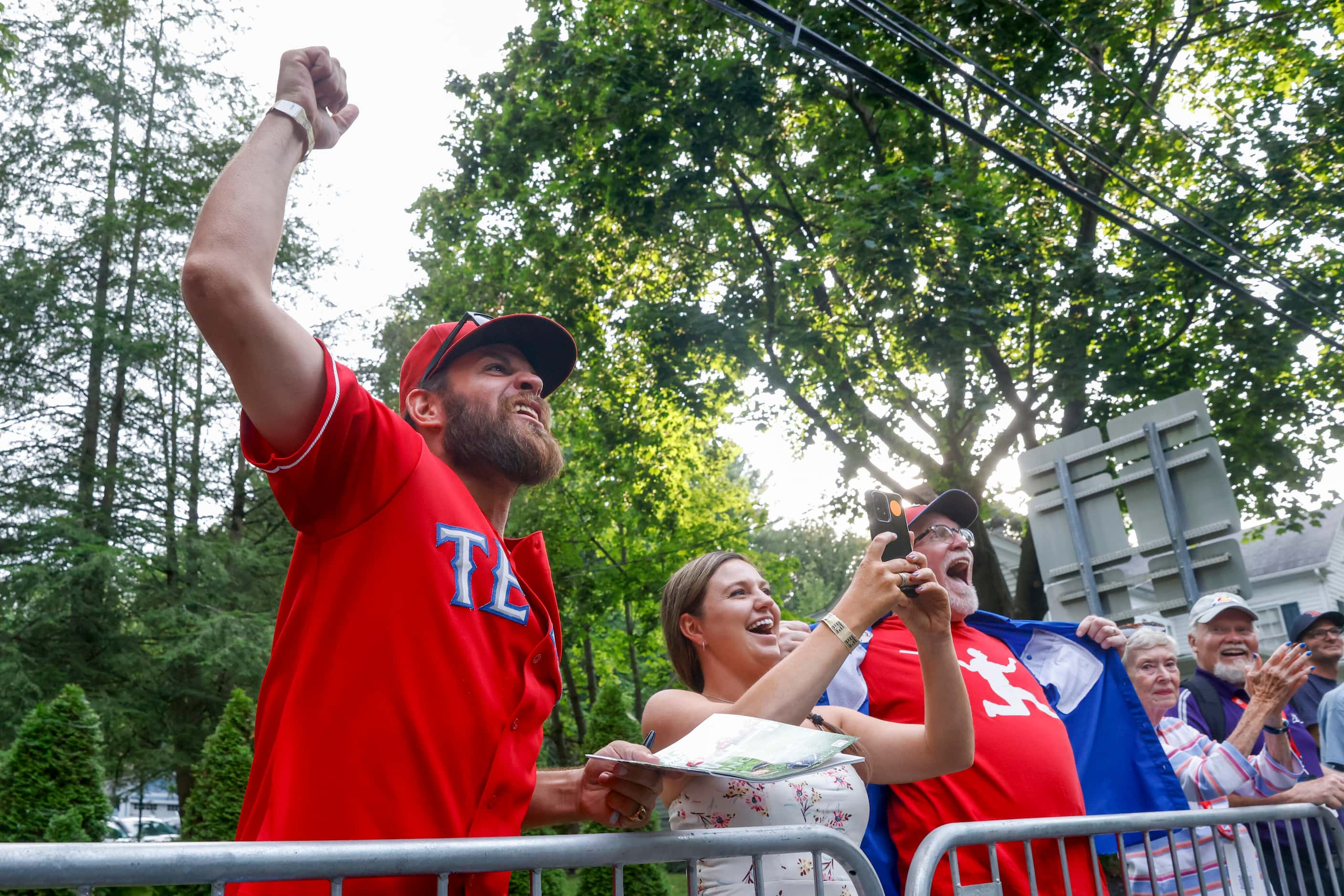 Texas Rangers fans Andrew Keith (left), Nina Dawson (center) and Rob Keith cheer for former...