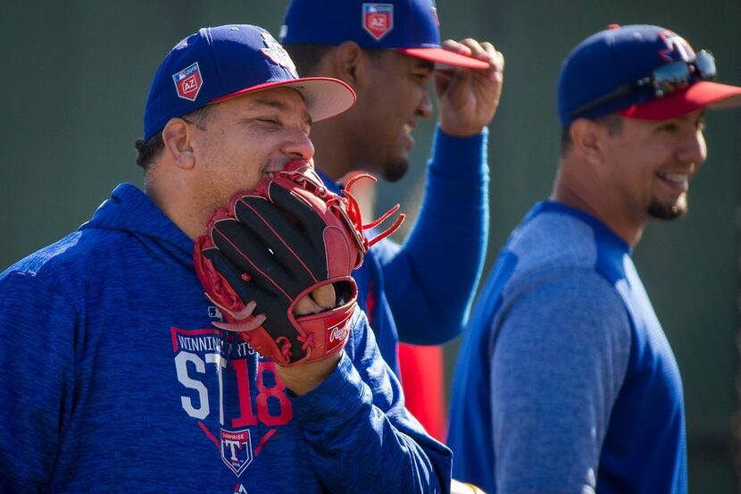 Texas Rangers pitcher Bartolo Colon laughs with teammates during a spring training workout...
