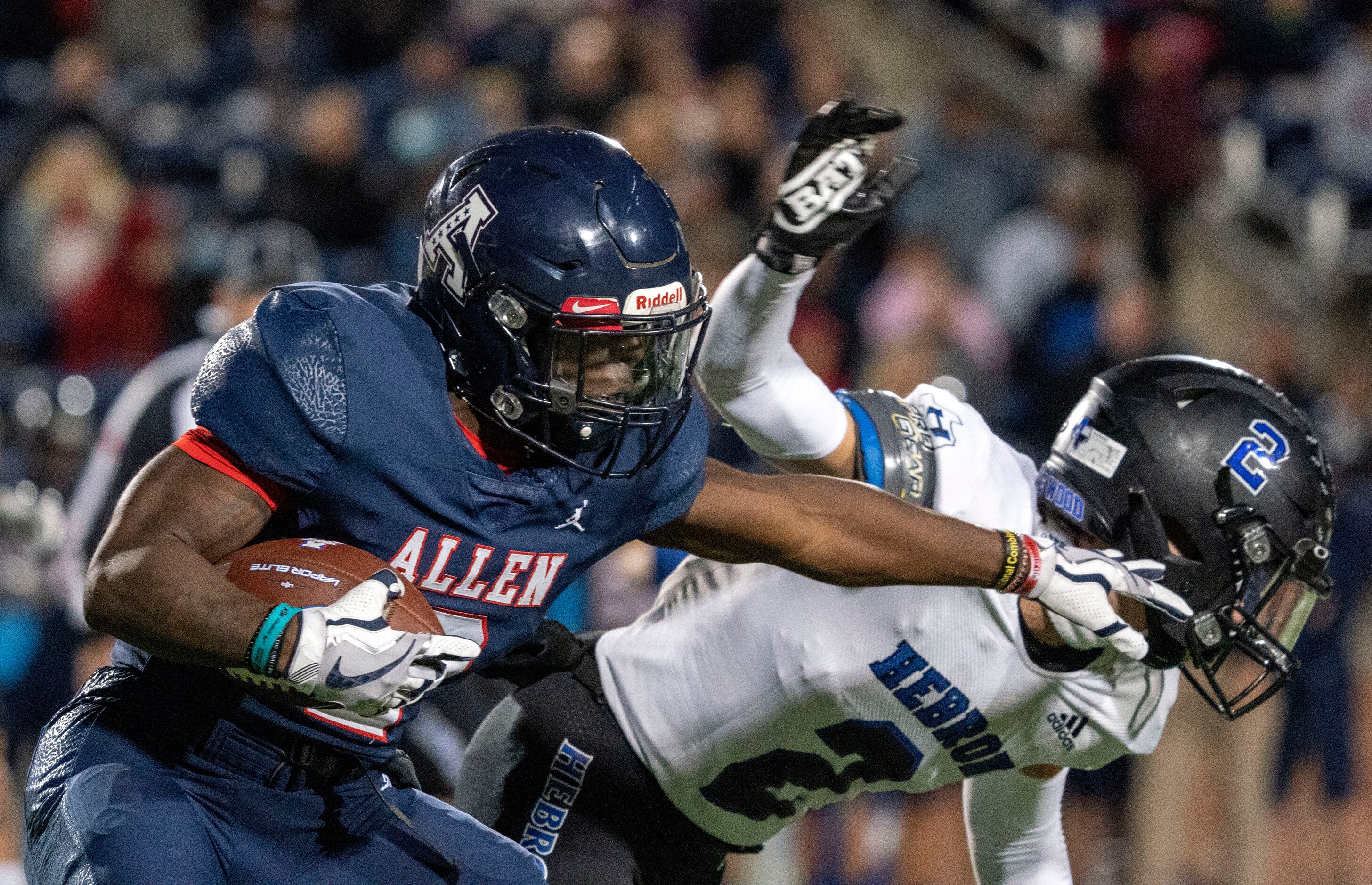 Allen senior running back Jaylen Jenkins (2) stiff-arms a Hebron defender during the first...