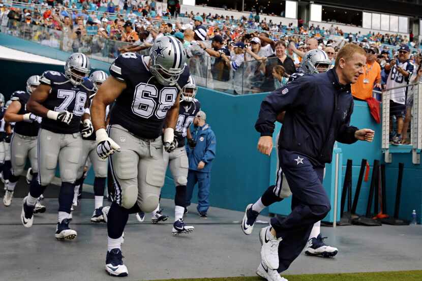 Dallas Cowboys head coach Jason Garrett (right) and the team run on the field before their...