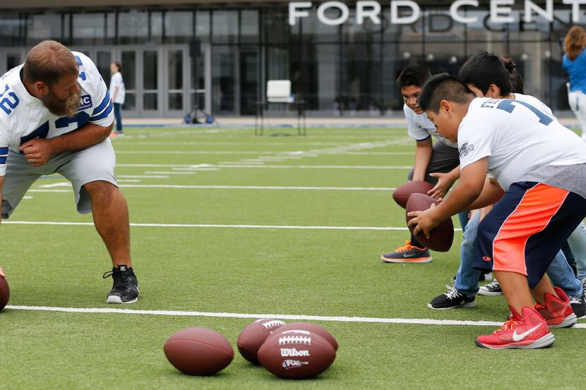 Dallas Cowboys center Travis Frederick (72) explains the next exercise to fourth graders...