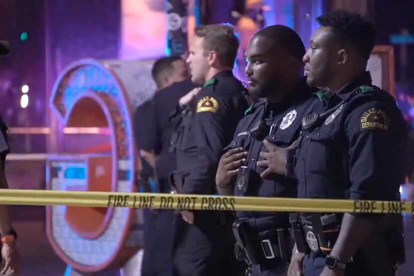 Dallas police officers survey the scene after multiple people were wounded in gunfire in...