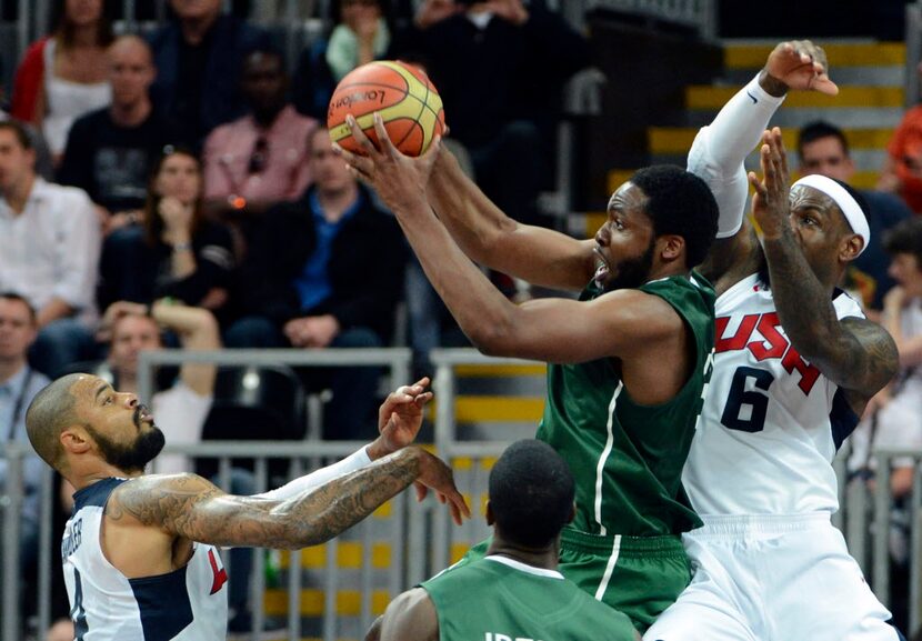 Nigeria's Ike Diogu (6) secures a rebound as USA's Lebron James (6) and Tyson Chandler (4)...