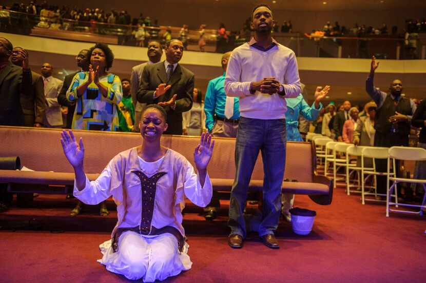 Theresa Cain, bottom left, worships during the praise and worship portion of Oak Cliff Bible...