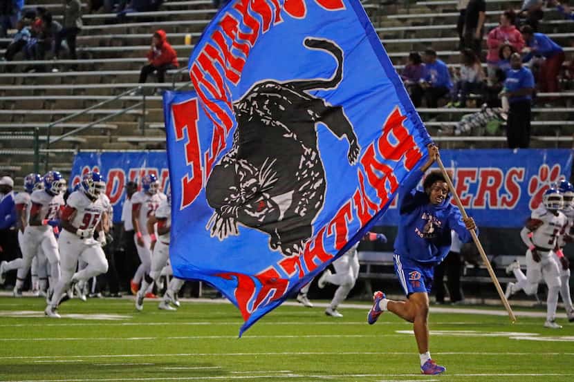 The flag crew leads the Duncanville Panthers onto the field during the South Grand Prairie...