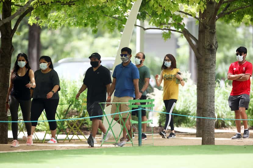 DALLAS, TX - JUN:  A group of people walks in Clyde Warren Park in Dallas, TX on Jun 27,...