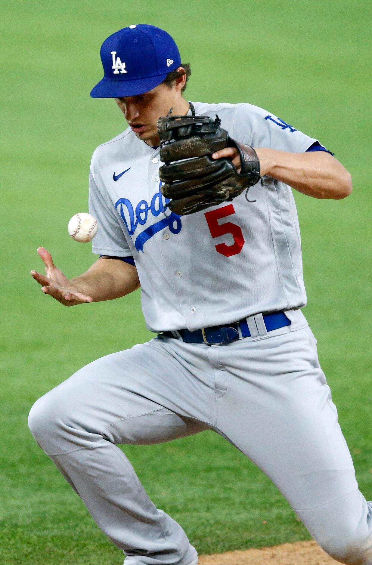 Los Angeles Dodgers shortstop Corey Seager (5) fields an infield hit before throwing to...