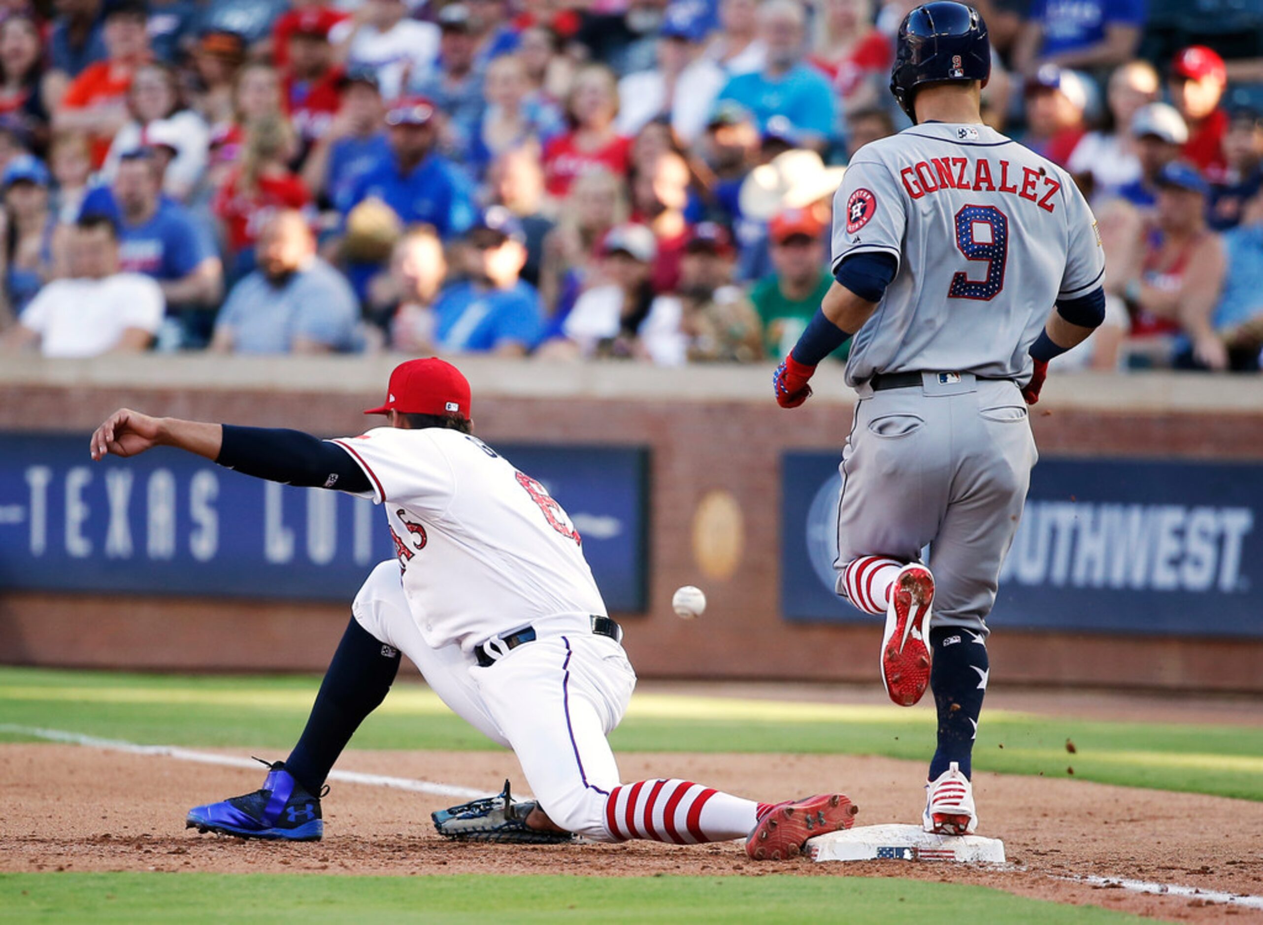 Houston Astros' Marwin Gonzalez (9) reaches first as Texas Rangers first baseman Ronald...