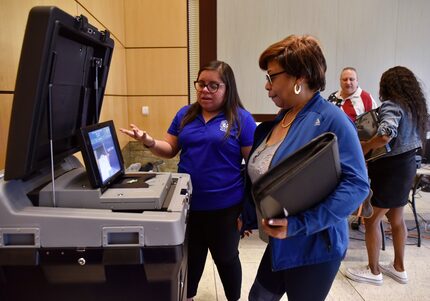 Laura Varela, izq., una coordinadora bilingüe de la Oficina Electoral de Dallas, explica...