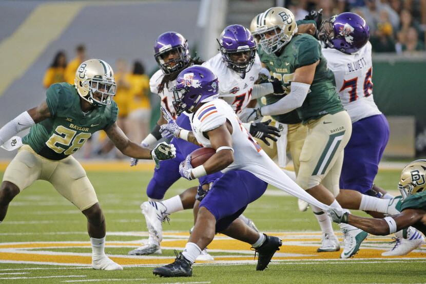 Baylor defensive back Patrick Levels (21), at right, grabs the jersey of Northwestern State...