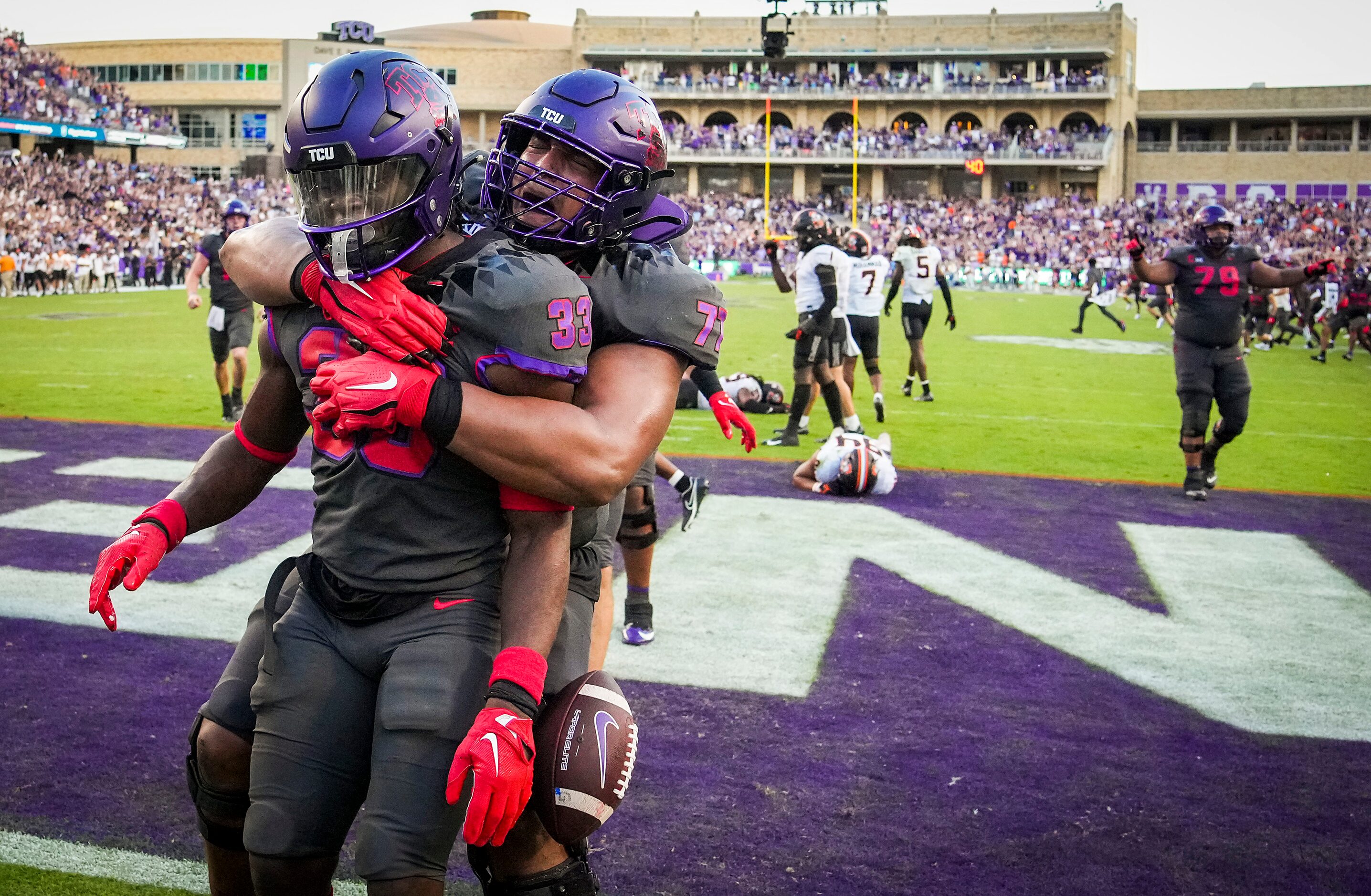 TCU running back Kendre Miller (33) celebrates with offensive tackle Brandon Coleman (77)...