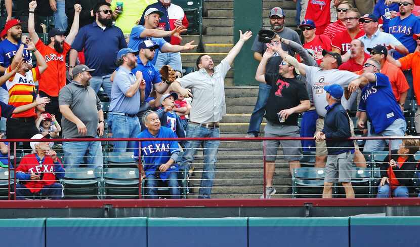 FILE - Fans in right field leap to catch George Springer's first-inning home run during a...