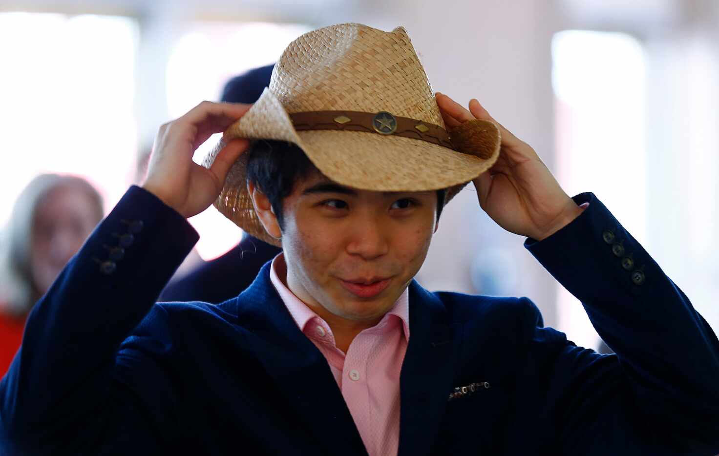 Hong Kim tries on a cowboy hat at the competitor orientation for The Fifteenth Van Cliburn...