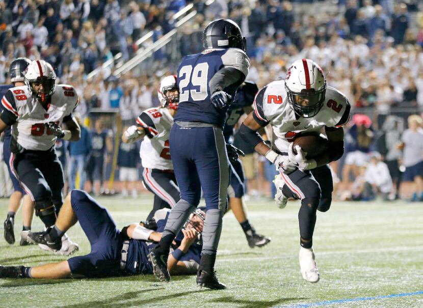 Flower Mound Marcus running back Justin Dinka (2) bounds into the end zone for the winning...